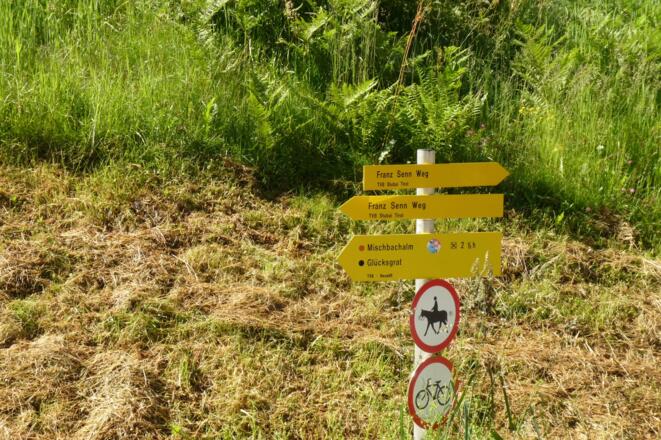 Am Ortsende weisen Wegtafeln in Richtung Mischbachalm bzw. Glücksgrat.