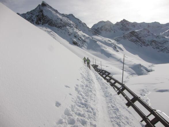 Steilhang mit Lawinenverbauung gleich am Beginn der langen Qerung entlang des Ostufers des Speichersees.