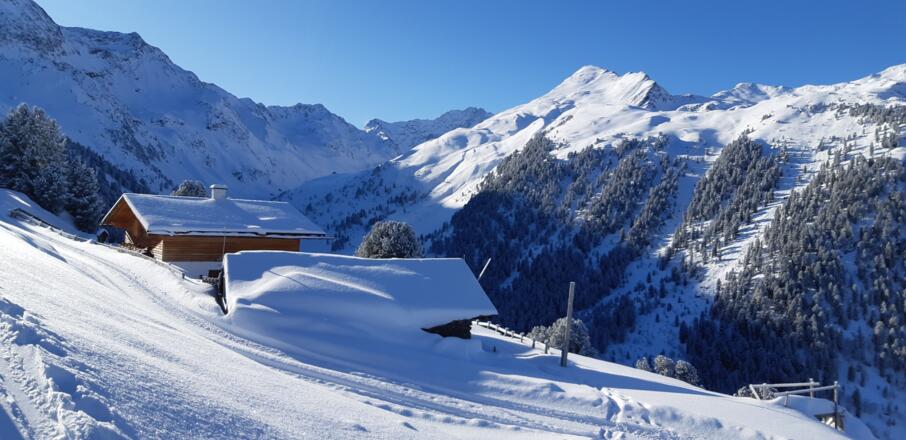 Hütten knapp unter der Furggesalm. Hinten kann man die Potsdamer Hütte erkennen, ganz hinten, im Schatten, die Hohe Villerspitze (3087 m).