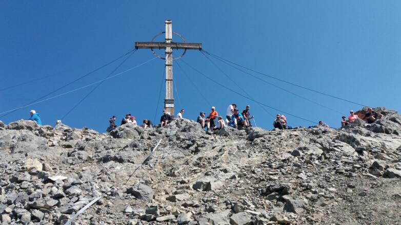 Unmittelbar vor dem Gipfelkreuz mit vielen Besuchern.