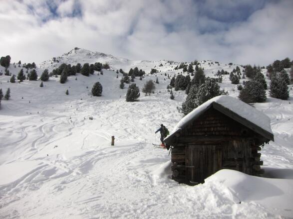 Von dieser kleinen Jagdhütte ist das Gipfelkreuz gut sichtbar. Man hält zunächst noch auf den breiten Gratrücken rechts des Gipfels zu.