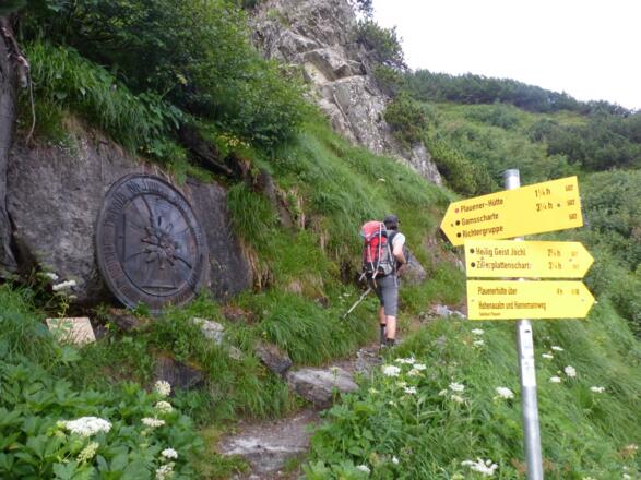Wegschilder und eine Tafel weisen den Anstieg zur Plauener Hütte.