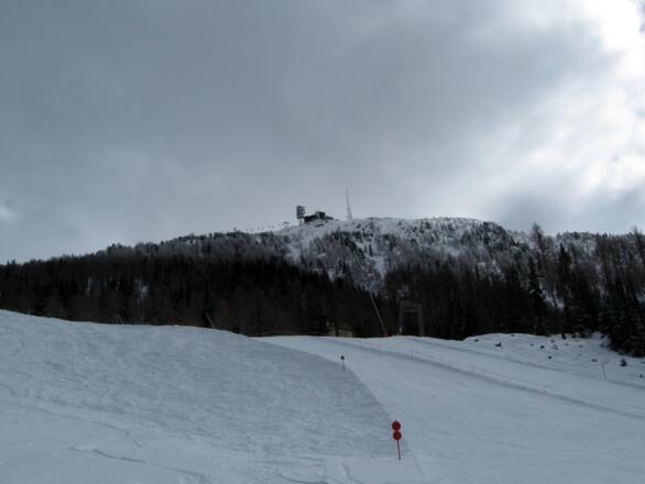 Die Abfahrt erfolgt über das Pistennetz. Rückblick zum Gipfel.