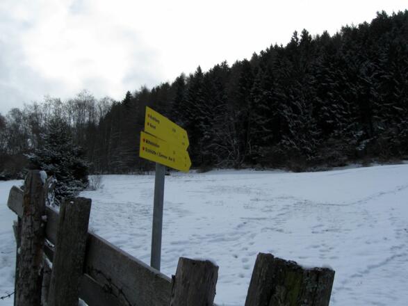 Hinter dem Zaun folgt man diesem Wegweiser.