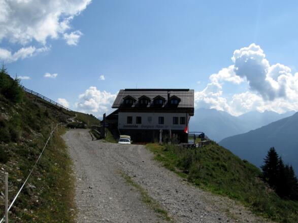 Die Alm ist rasch erreicht. Wie ein Adlerhorst klebt sie an den steilen Wiesenhängen.