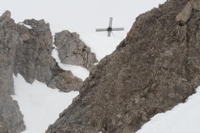 Bei der Abfahrt schweift der Blick nochmals zurück zum Gipfelkreuz.