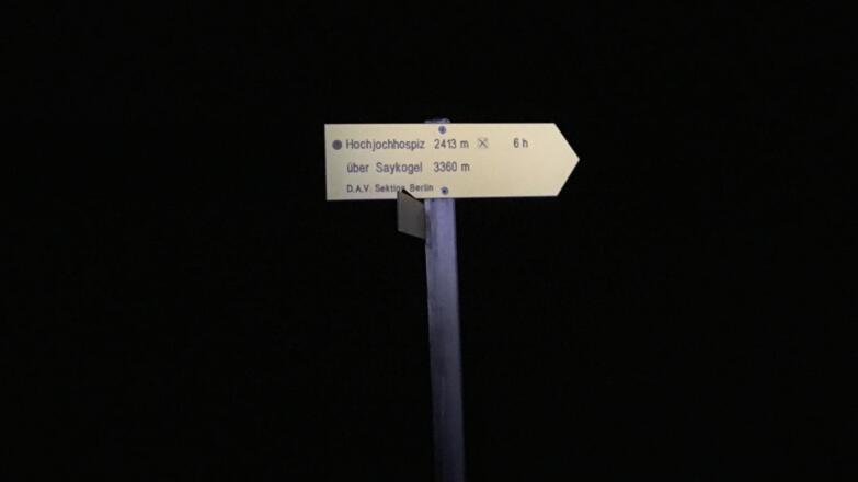 Wegweiser zum Saykogel im Licht der Strinlampe