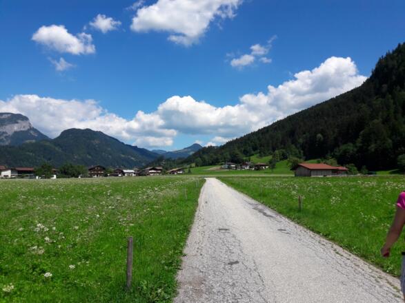Über die Wiese bis zu den Häusern, dann rechts.