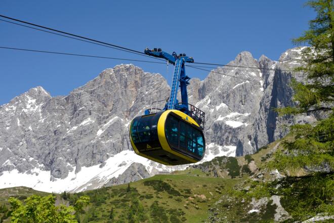 In den rundum verglasten Panoramagondeln der Dachstein-Südwandbahn schweben Gäste hinauf zur Bergstation am Hunerkogel.