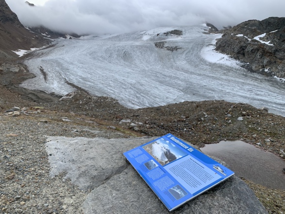 Tafel des Gletscherlehrpfades. Im Hintergrund der Silvrettagletscher