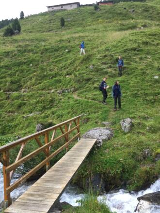 Von der Hütte geht es kurz hinab zu einem Bachlauf mit Brücke