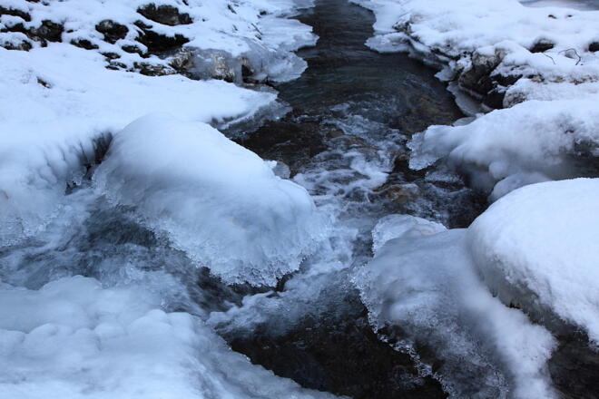Bach sucht sich seinen Weg durch Eis und Schnee