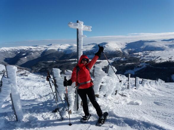 M. vor verblasenem vereisten Wegweiser, rundum eine herrliche Aussicht.