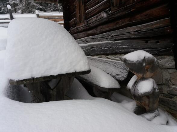 Große geschnitzte Holzmaus vor der alten Kocherhütte.